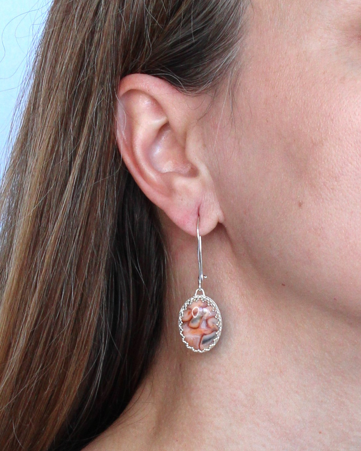 Lace Agate Oval Gemstones in Pink and Gray, set in a patterned sterling silver bezel with long texturized kidney ear wires. Handmade by Cara Carter Jewelry