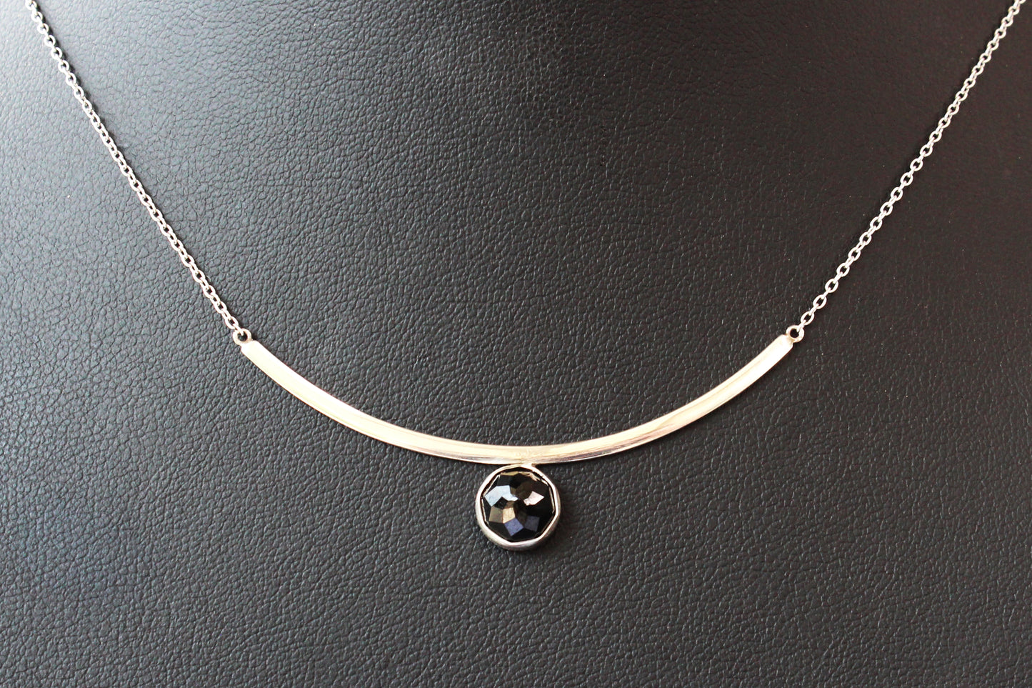 Black Spinel Faceted Gemstone on Minimalist Sterling Silver Curved Bar Necklace. Handmade by Cara Carter Jewelry