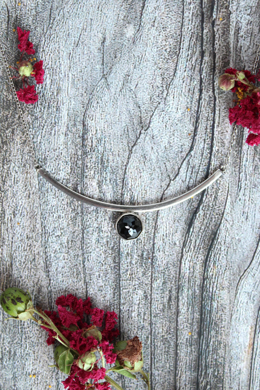 Black Spinel Faceted Gemstone on Minimalist Sterling Silver Curved Bar Necklace. Handmade by Cara Carter Jewelry