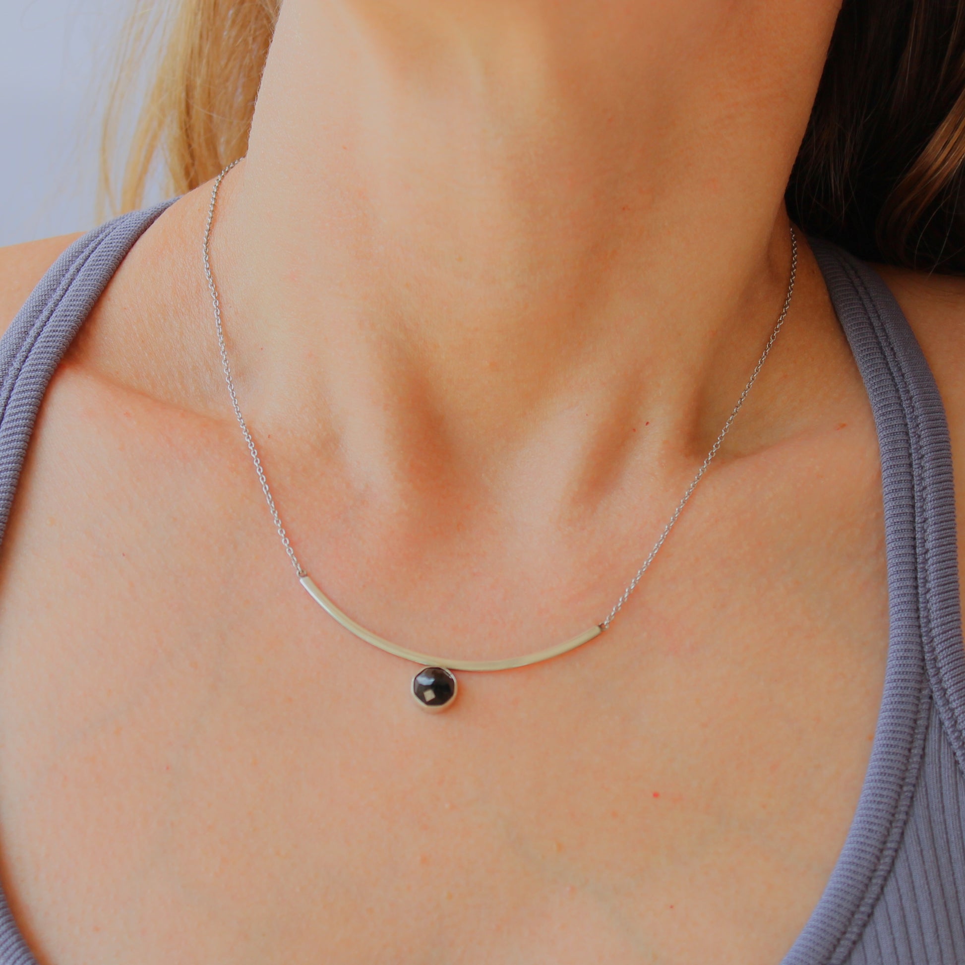 Black Spinel Faceted Gemstone on Minimalist Sterling Silver Curved Bar Necklace. Handmade by Cara Carter Jewelry