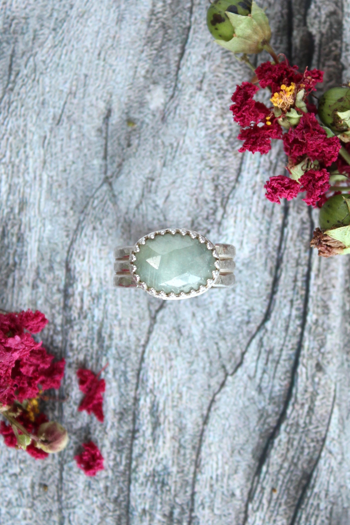 Natural Faceted Light Green Oval Sapphire Set in Sterling Silver with a triple band and patterned bezel. One of a kind and handmade by Cara Carter Jewelry