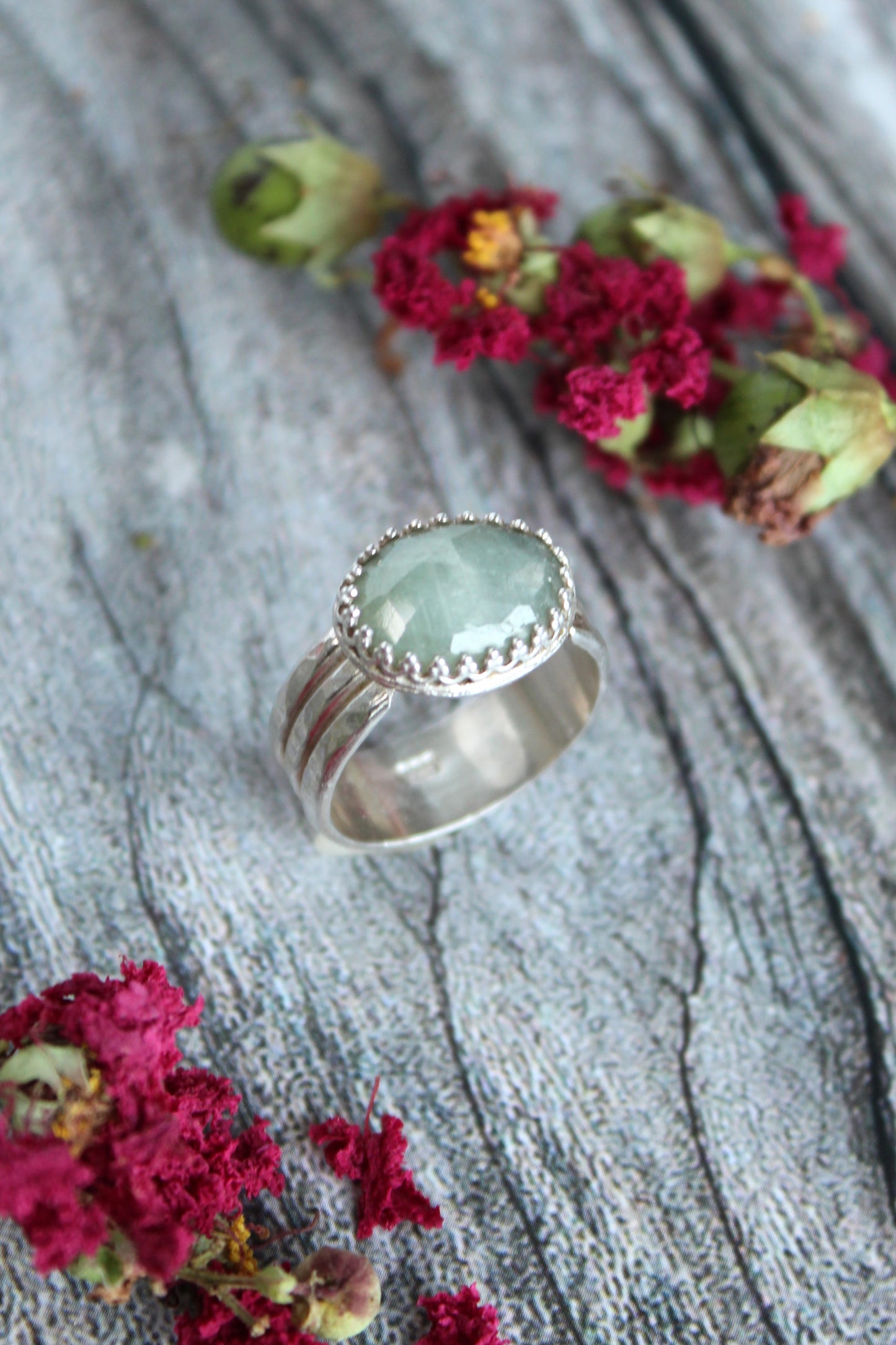 Natural Faceted Light Green Oval Sapphire Set in Sterling Silver with a triple band and patterned bezel. One of a kind and handmade by Cara Carter Jewelry