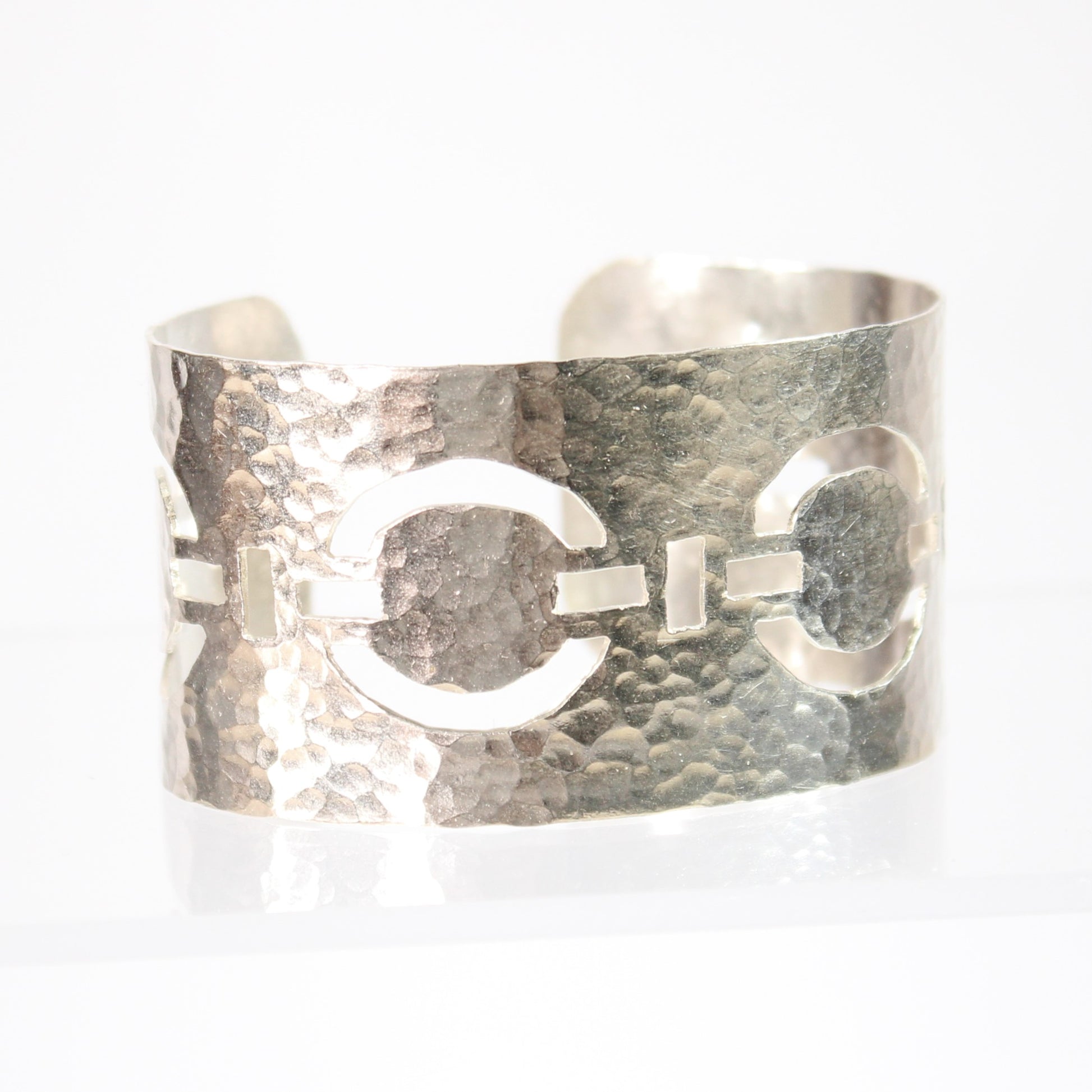 Meticulously pierced and hammered by hand from sterling silver, this handcrafted statement cuff features a stylish linked circle chain design. This wide yet comfortable cuff bracelet is versatile and adds a touch of sophistication to any ensemble, day or night.